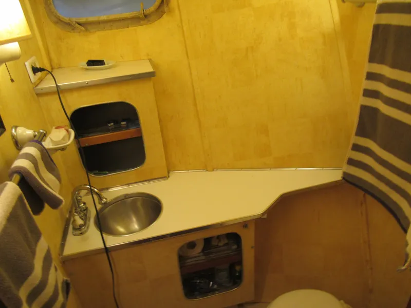 Slide: The Image of 1963 Chris-Craft Constellation bathroom with wooden interior and compact sink. - 18