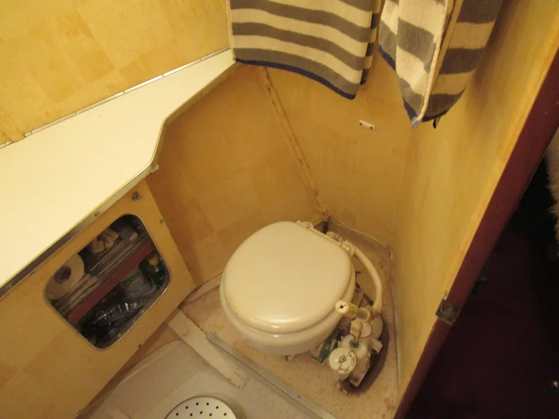 Slide: The Image of 1963 Chris-Craft Constellation boat bathroom with toilet and striped towels. - 19