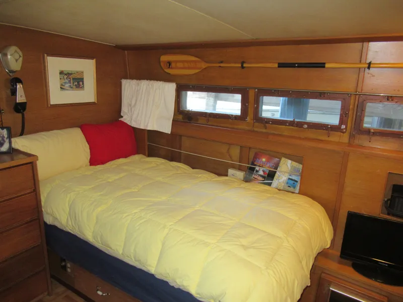 Slide: The Image of Cozy cabin interior of 1963 Chris-Craft Constellation with bed, wooden walls, and decor. - 21
