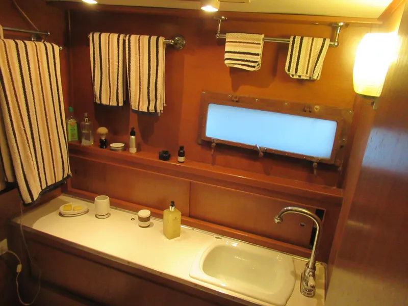 Slide: The Image of 1963 Chris-Craft Constellation bathroom with wooden interior, striped towels, and a small sink. - 24