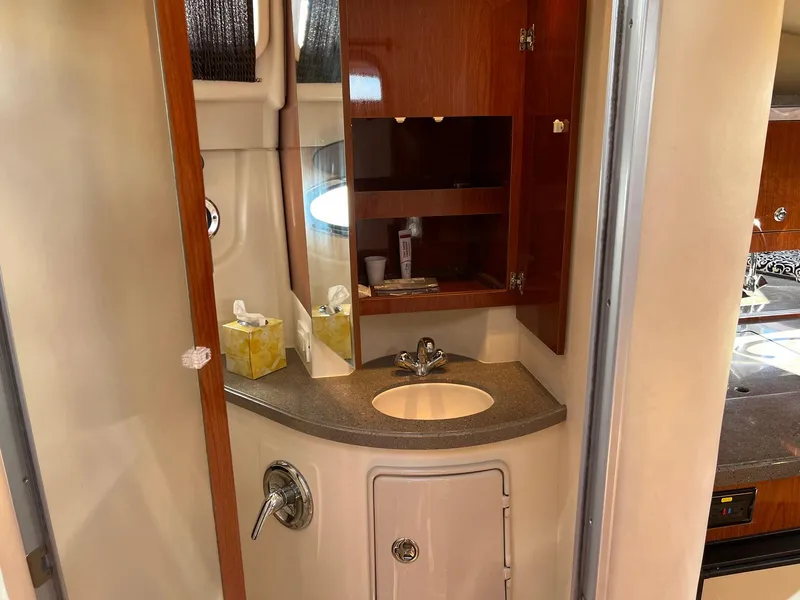 Slide: The Image of 2011 Regal 35 Express Cruiser bathroom with sink, mirror, and wooden cabinet. - 13