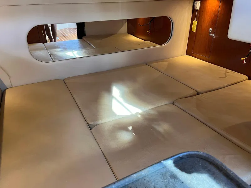 Slide: The Image of 2011 Regal 35 Express Cruiser cabin interior with beige cushions and a wall mirror. - 16