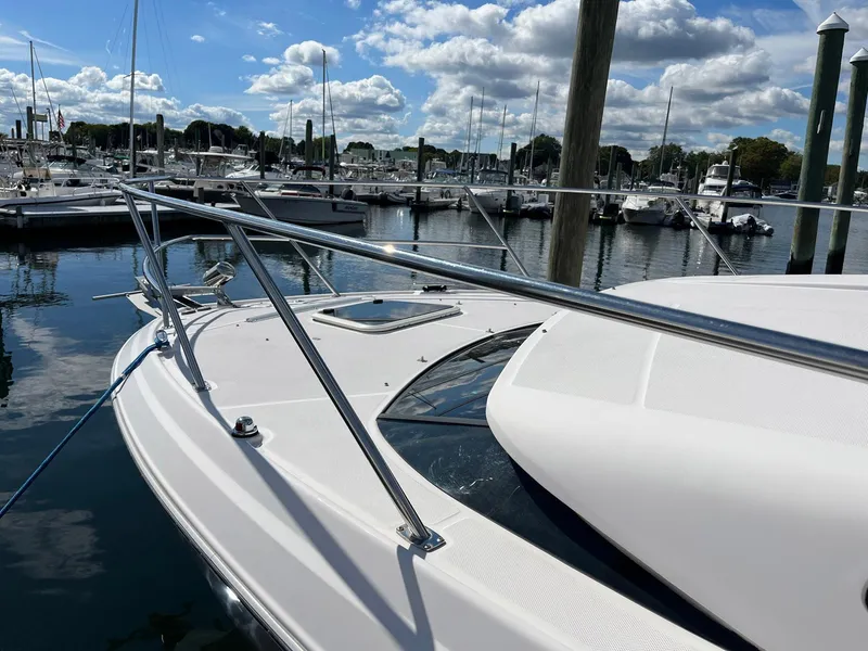 Slide: The Image of 2011 Regal 35 Express Cruiser docked at a marina under a partly cloudy sky. - 2