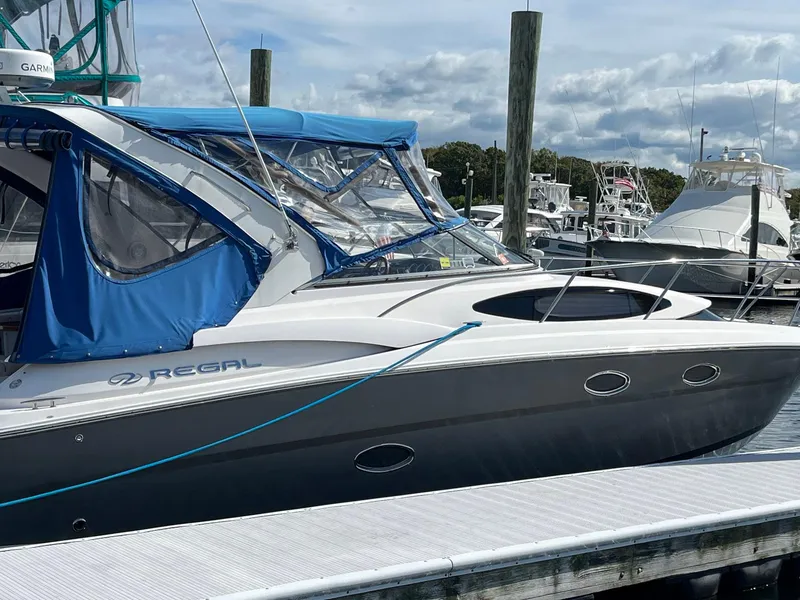 Slide: The Image of 2011 Regal 35 Express Cruiser docked with blue canopy in marina. - 21