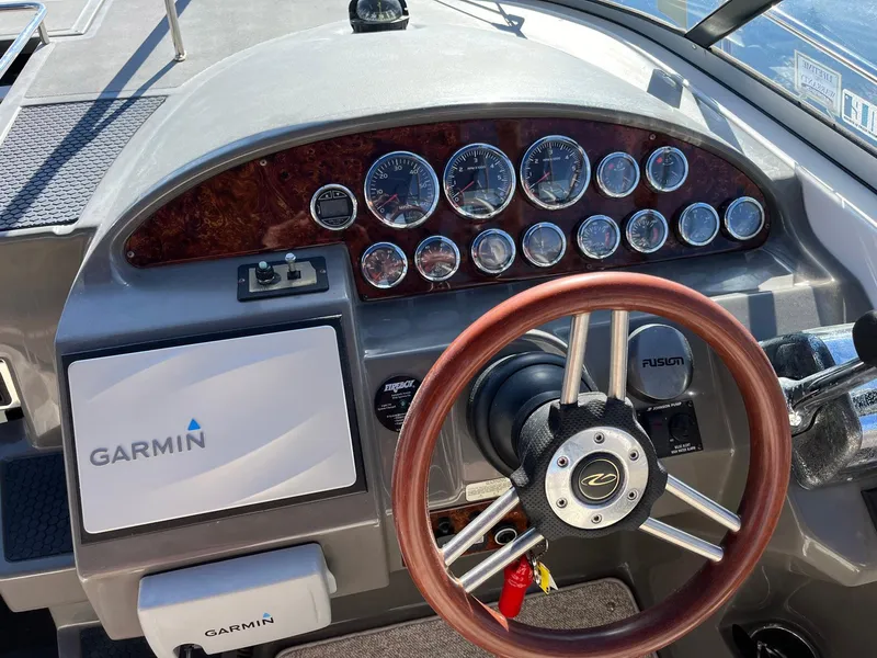 Slide: The Image of Helm of 2011 Regal 35 Express Cruiser with Garmin navigation and wood-accented dashboard. - 23