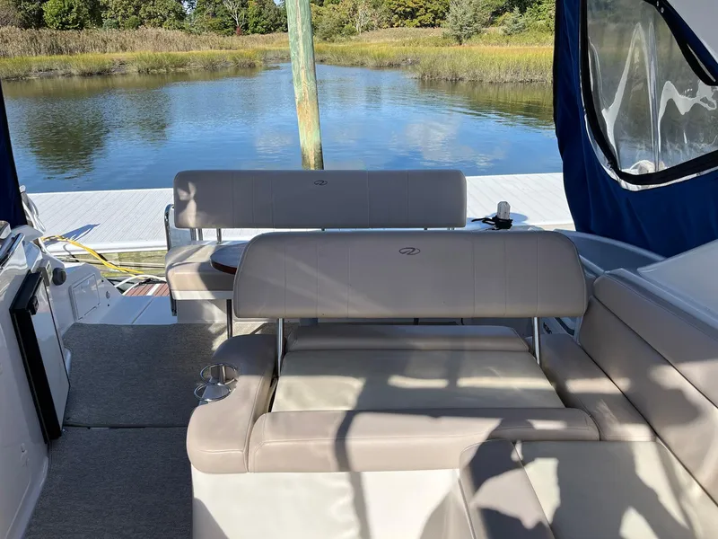 Slide: The Image of 2011 Regal 35 Express Cruiser interior with seating, docked by a serene lake. - 29