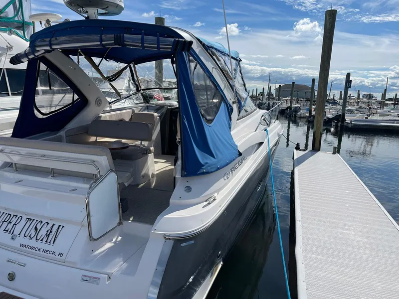 Slide: The Image of 2011 Regal 35 Express Cruiser docked at marina with blue canopy. - 39