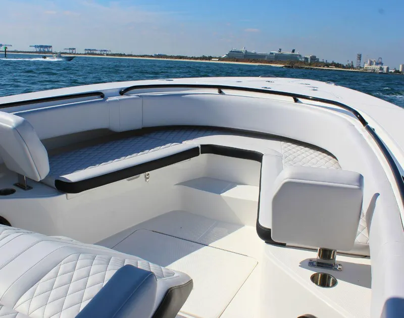 Slide: The Image of 2025 Fountain 34 CC boat interior with white seating, on a sunny day at sea. - 21