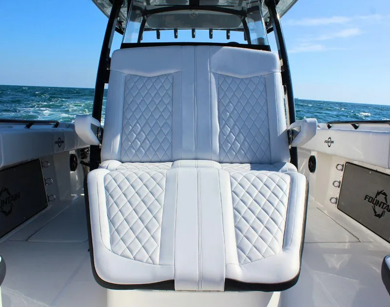 Slide: The Image of 2025 Fountain 34 CC boat with luxurious white quilted seating, ocean backdrop. - 22