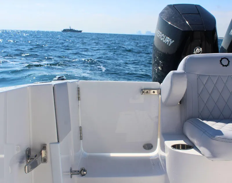 Slide: The Image of 2025 Fountain 34 CC boat interior with Mercury engine, ocean view in background. - 8