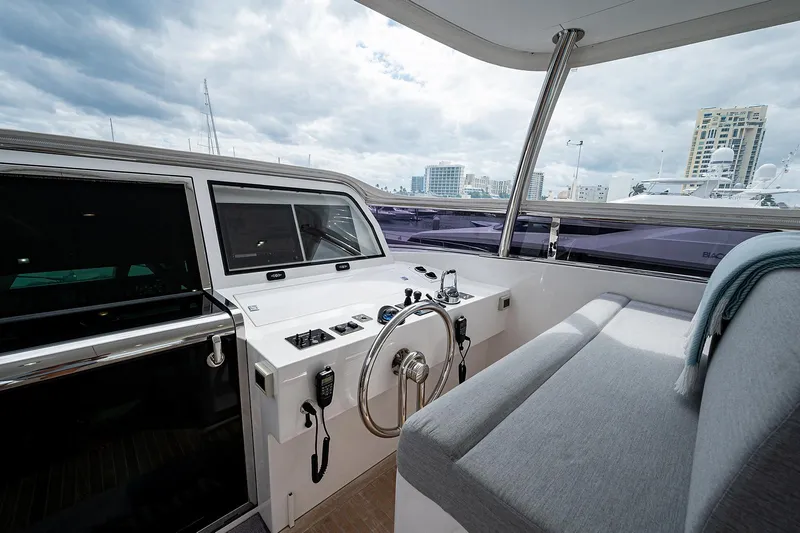 Slide: The Image of Interior view of 2014 Horizon RP 110 yacht, featuring helm and seating area under cloudy sky. - 38