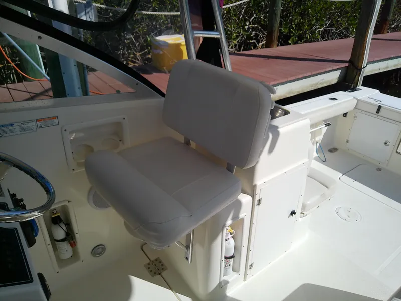 Slide: The Image of 2006 Pursuit 3070 Offshore boat interior with white seating and control area. - 22