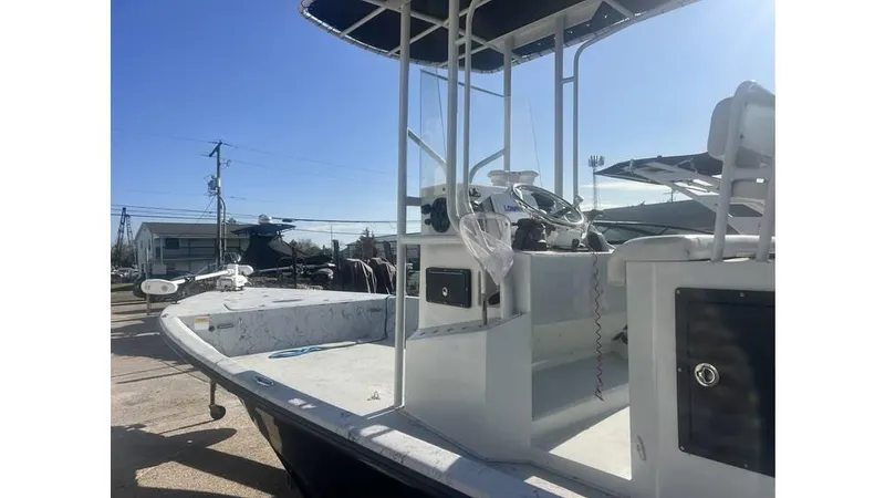 Slide: The Image of 2016 Majek 25 Xtreme boat with center console and seating, docked under clear sky. - 6