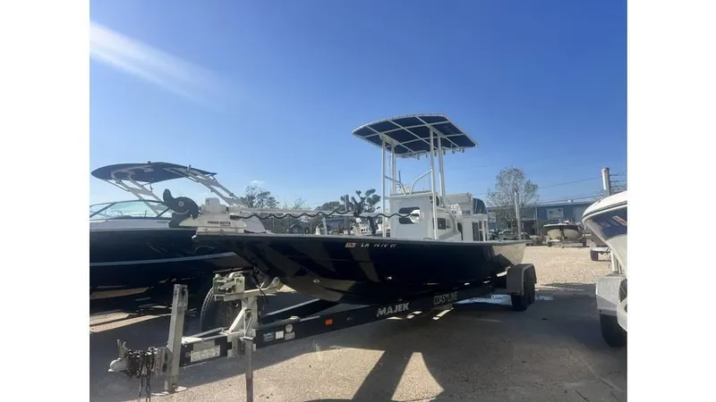 Slide: The Image of 2016 Majek 25 Xtreme boat on trailer under clear blue sky. - 8