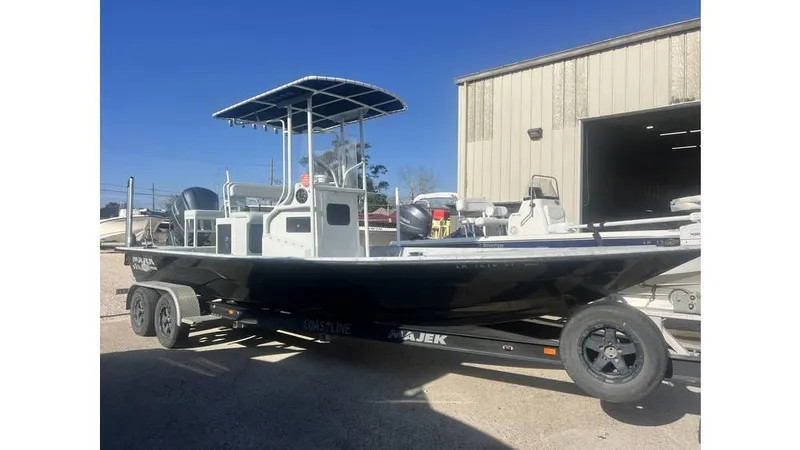 Slide: The Image of 2016 Majek 25 Xtreme boat on trailer, parked outside a warehouse. - 9