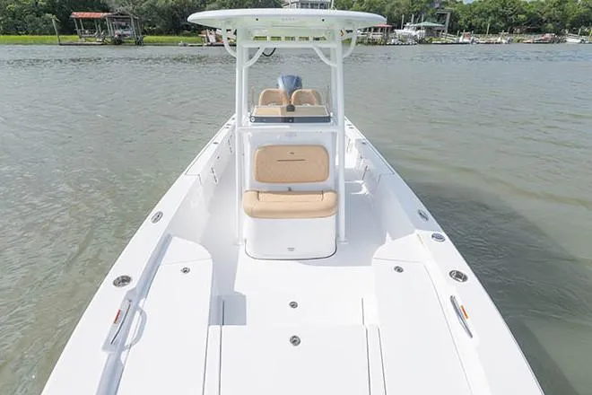 Slide: The Image of 2019 Sportsman Masters 247 Bay Boat on calm water, featuring spacious deck and seating. - 12