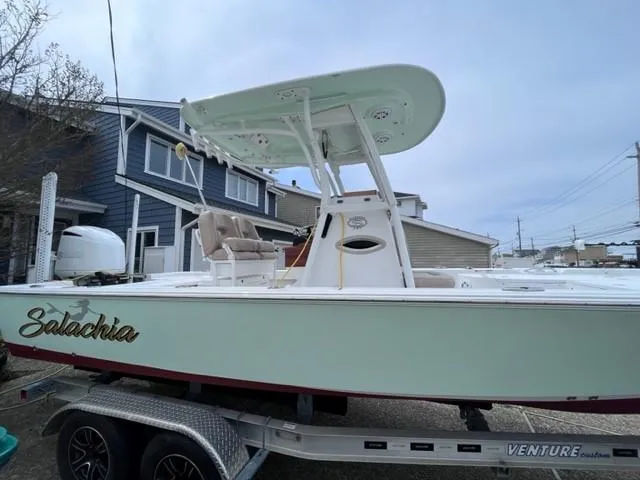 Slide: The Image of 2019 Sportsman Masters 247 Bay Boat on trailer, parked near houses. - 2