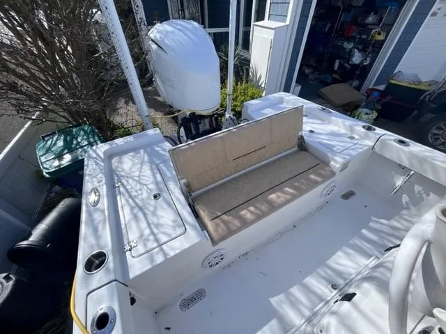 Slide: The Image of 2019 Sportsman Masters 247 Bay Boat with seating and outboard motor in a driveway. - 22