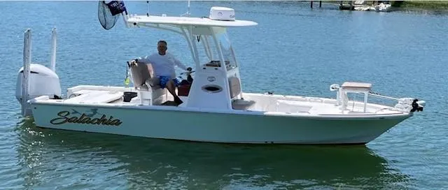 Slide: The Image of 2019 Sportsman Masters 247 Bay Boat on water, featuring sleek design and spacious deck. - 5