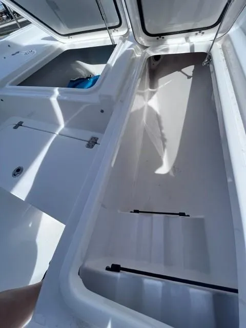 Slide: The Image of 2019 Sportsman Masters 247 Bay Boat storage compartments open, showcasing spacious interior. - 9