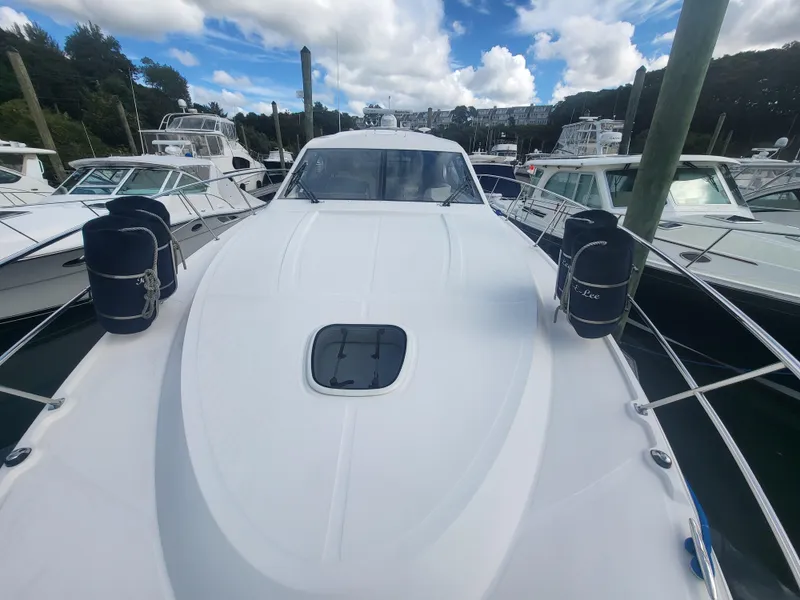 Slide: The Image of 2013 Sea Ray 510 Sundancer yacht docked among other boats under a cloudy sky. - 24