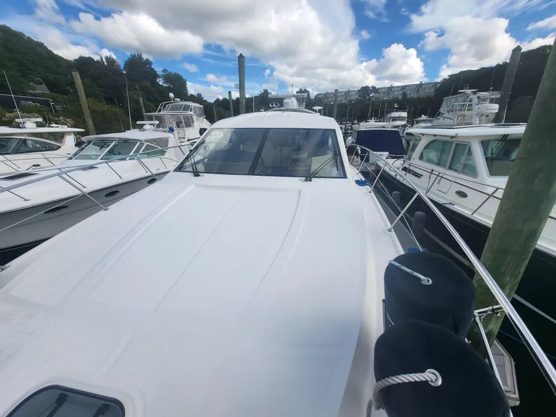Slide: The Image of 2013 Sea Ray 510 Sundancer yacht docked among other boats under a partly cloudy sky. - 25