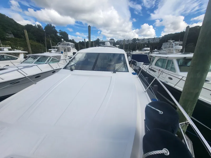Slide: The Image of 2013 Sea Ray 510 Sundancer yacht docked among other boats under a partly cloudy sky. - 26