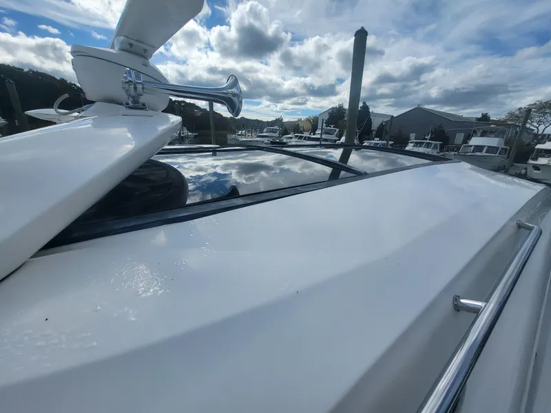 Slide: The Image of 2013 Sea Ray 510 Sundancer yacht, sleek design, docked under cloudy sky. - 33