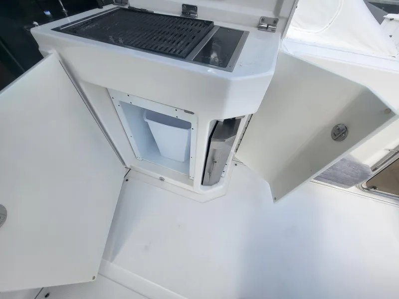 Slide: The Image of 2013 Sea Ray 510 Sundancer yacht interior with open storage compartments and grill. - 41
