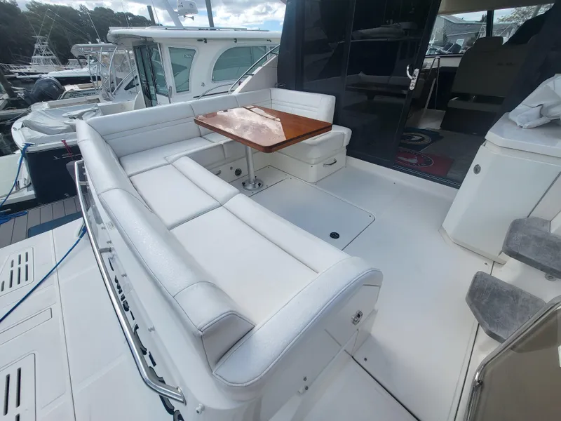 Slide: The Image of 2013 Sea Ray 510 Sundancer yacht with spacious outdoor seating and wooden table. - 45