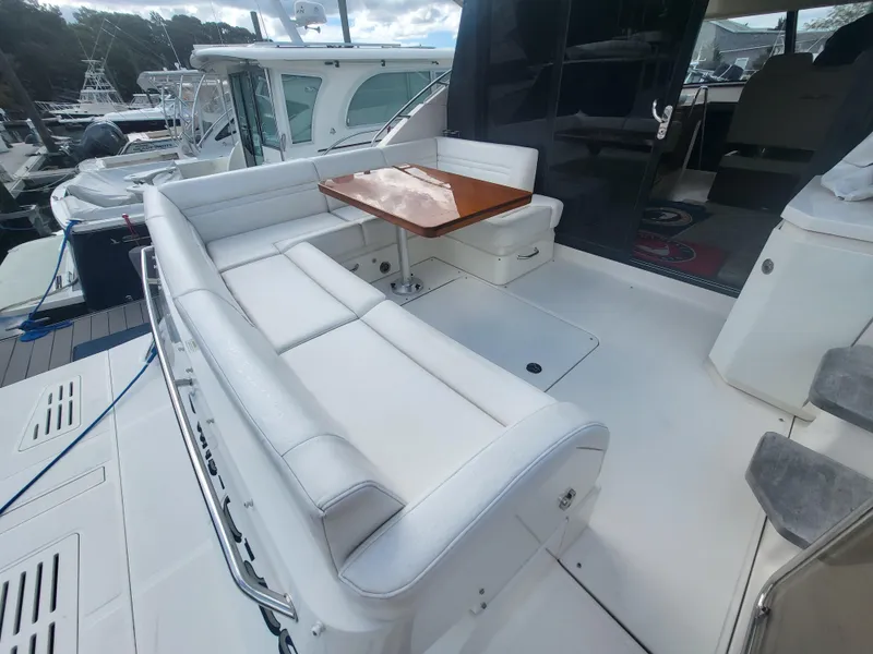 Slide: The Image of 2013 Sea Ray 510 Sundancer yacht with white seating and wooden table on deck. - 46