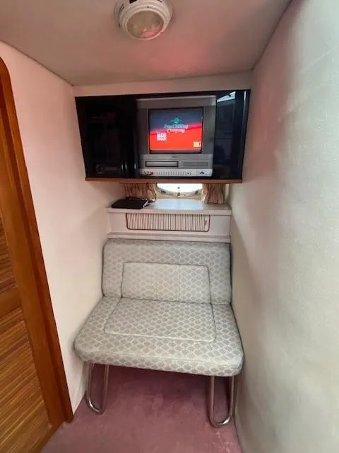 Slide: The Image of 1992 Regal 40 Commodore interior with TV, cushioned seating, and wood accents. - 14