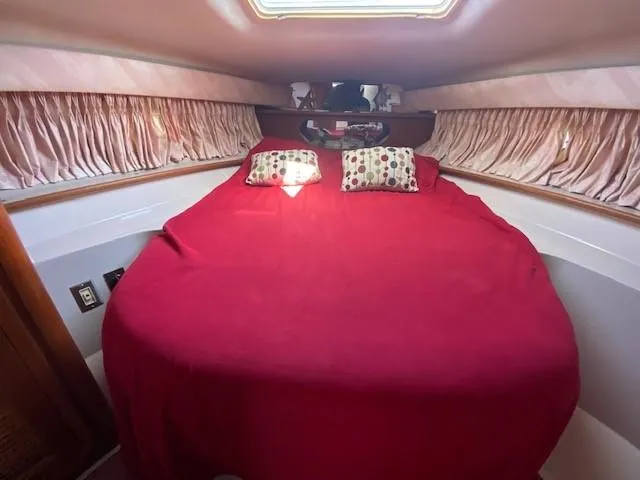 Slide: The Image of Cozy cabin interior of 1992 Regal 40 Commodore with red bedding and decorative pillows. - 16