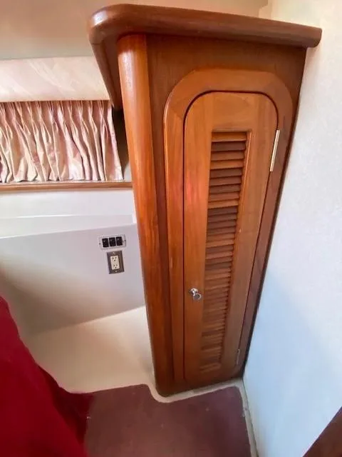 Slide: The Image of Wooden cabinet inside 1992 Regal 40 Commodore yacht, featuring louvered door and elegant design. - 18