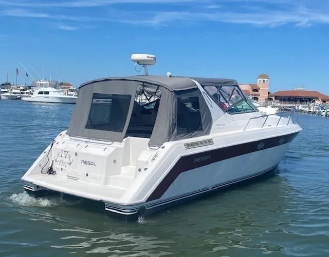Slide: The Image of 1992 Regal 40 Commodore boat cruising in a marina under a clear blue sky. - 25