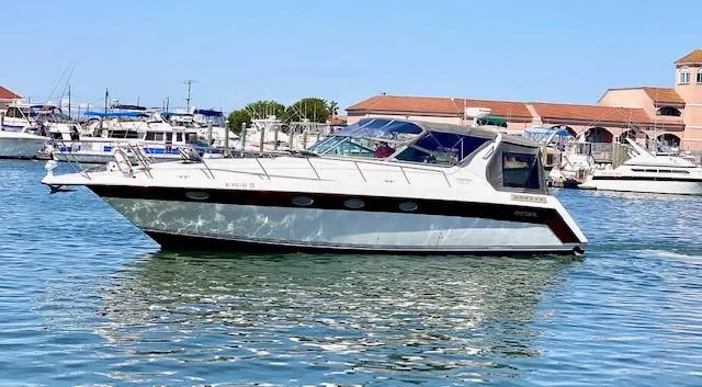 Slide: The Image of 1992 Regal 40 Commodore yacht cruising in a marina with clear blue skies. - 4