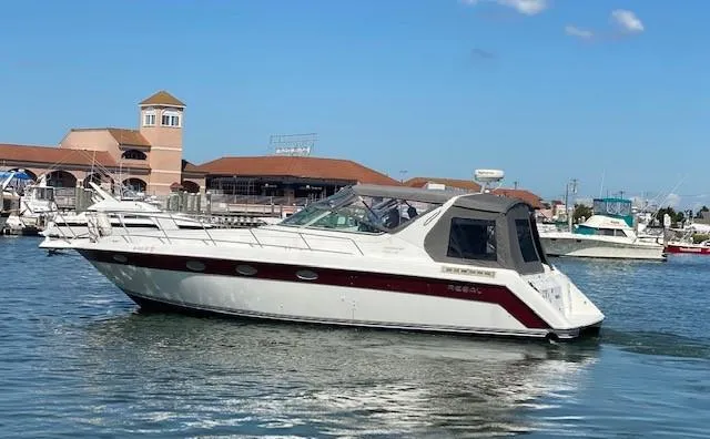 Slide: The Image of 1992 Regal 40 Commodore yacht docked in a marina with clear blue skies. - 5