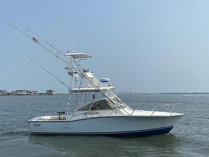 The Image of 2006 Carolina Classic 28 Express boat on calm water, with clear sky background. - 0