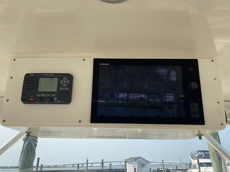 Slide: The Image of 2006 Carolina Classic 28 Express boat dashboard with electronic navigation and communication equipment. - 12
