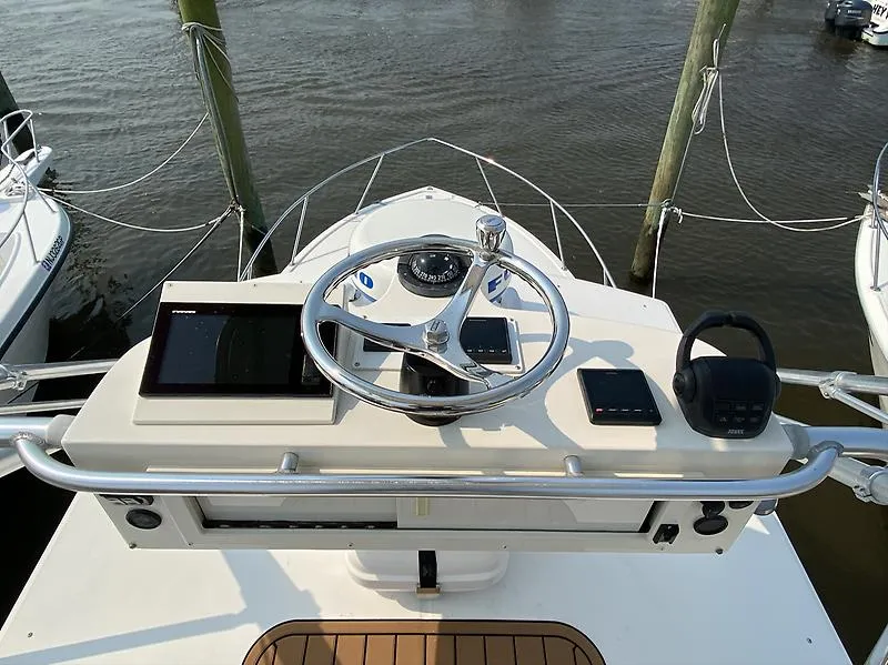 Slide: The Image of 2006 Carolina Classic 28 Express boat helm with steering wheel and navigation equipment. - 13