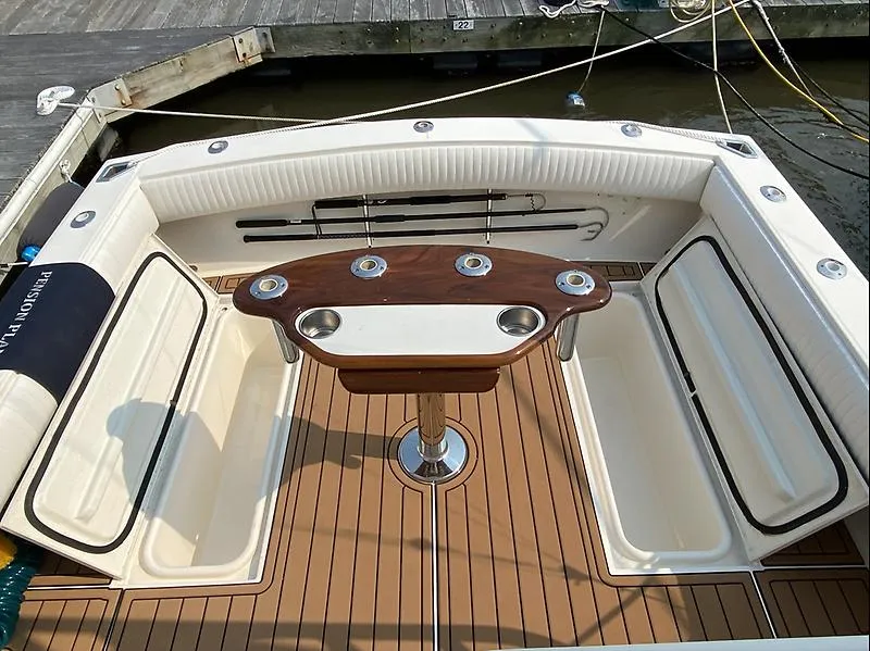 Slide: The Image of 2006 Carolina Classic 28 Express boat interior with wooden deck and seating area. - 16