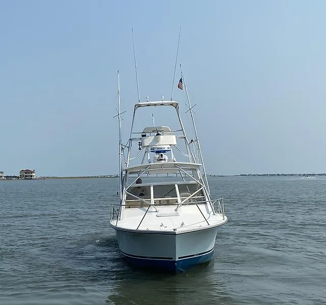 Slide: The Image of 2006 Carolina Classic 28 Express boat on calm water, front view. - 2