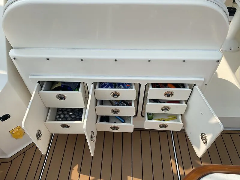 Slide: The Image of Storage compartments on a 2006 Carolina Classic 28 Express boat, with open drawers and cabinets. - 25