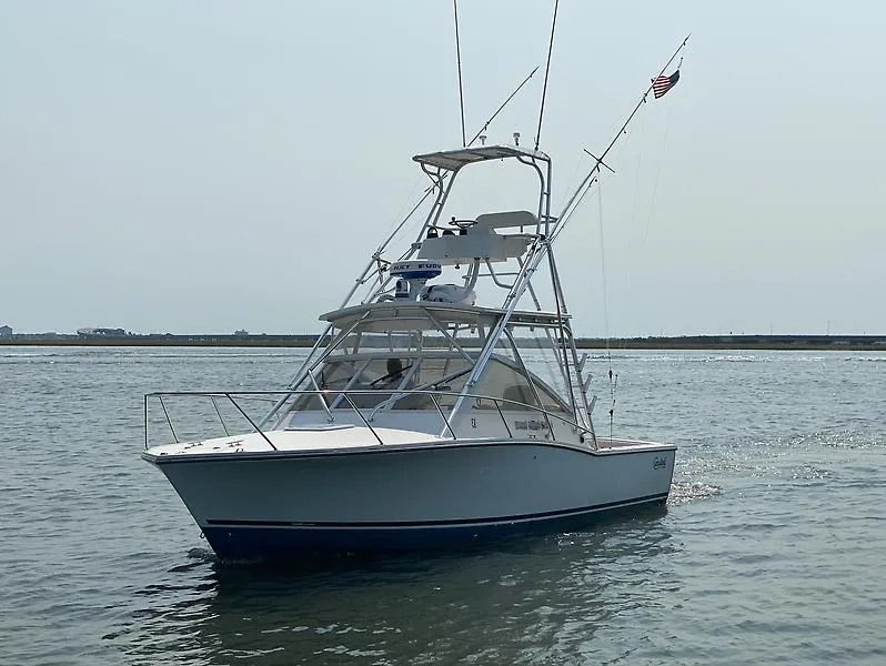 Slide: The Image of 2006 Carolina Classic 28 Express boat on calm water, featuring a fishing tower. - 3