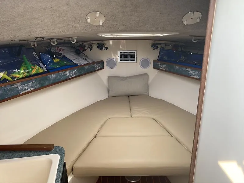 Slide: The Image of 2006 Carolina Classic 28 Express cabin interior with beige cushions and storage shelves. - 6