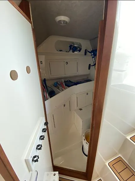 Slide: The Image of 2006 Carolina Classic 28 Express cabin interior with storage compartments and fishing gear. - 7