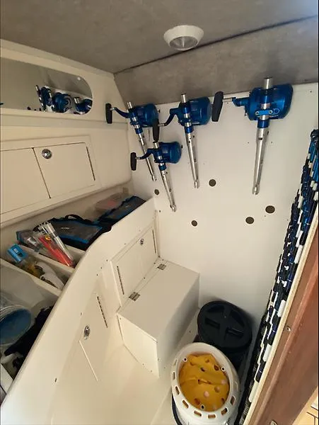 Slide: The Image of 2006 Carolina Classic 28 Express cabin with fishing gear and storage compartments. - 8