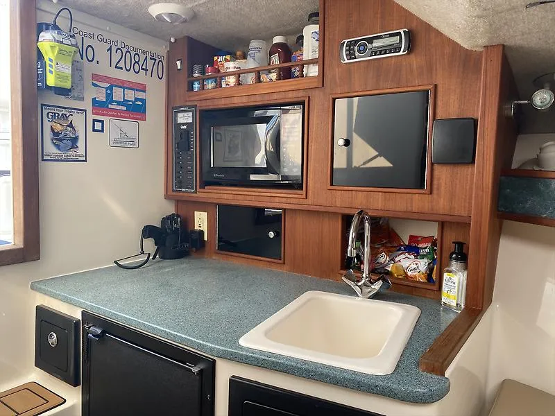 Slide: The Image of Interior of a 2006 Carolina Classic 28 Express boat kitchen with sink and microwave. - 9