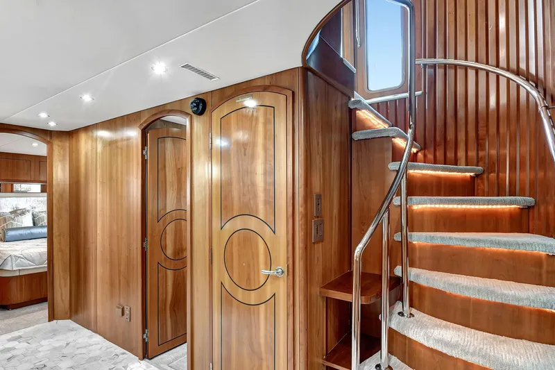 Slide: The Image of Luxurious 2005 Hatteras Semi-Displacement yacht interior with elegant wood paneling and spiral staircase. - 21