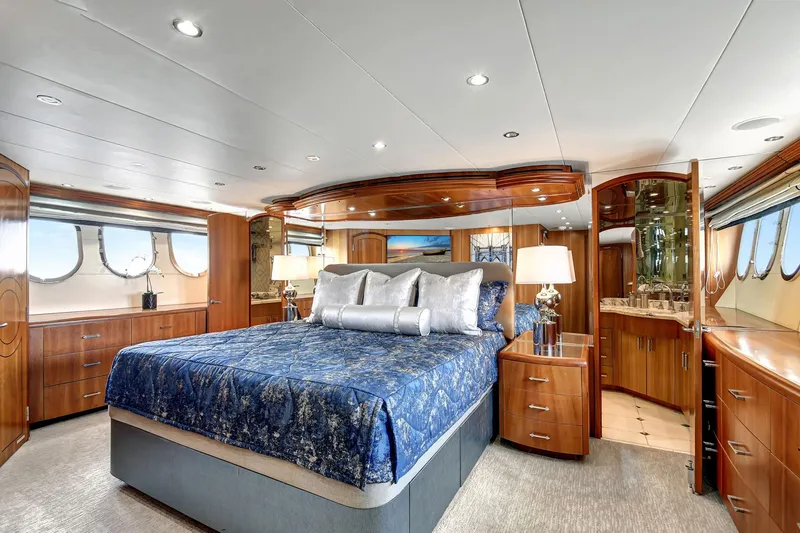 Slide: The Image of Luxurious 2005 Hatteras Semi-Displacement yacht bedroom with elegant wood finishes and large windows. - 22
